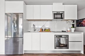 Ottawa apartment for rent - A modern kitchen with white cabinets and stainless steel appliances.