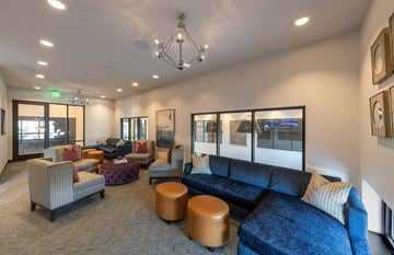 Richardson apartment for rent - A living room with a blue couch and a brown ottoman.