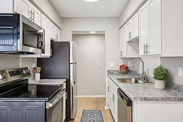 Canton apartment for rent - A kitchen with white cabinets and a black refrigerator.