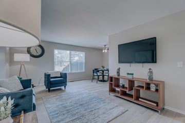 Troy apartment for rent - A living room with a blue couch and a wooden shelf.