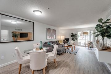 Ann Arbor apartment for rent - A living room with a glass table and white chairs.