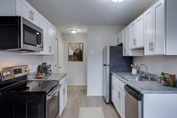 Canton apartment for rent - A kitchen with black appliances and white cabinets.