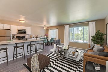 Sterling Heights apartment for rent - A well-lit kitchen with a bar area and a dining table set for two.