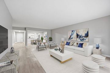 Bloomfield Hills apartment for rent - A modern living room with a white sofa and a large painting on the wall.