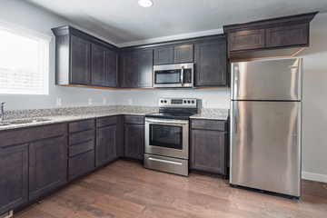 Herriman townhouse for rent - A kitchen with dark wood cabinets and stainless steel appliances.