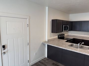 Magna apartment for rent - A kitchen with a sink and a white door.