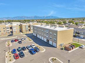 Magna apartment for rent - A parking lot with cars and a building in the background.