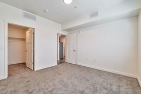 Magna apartment for rent - A spacious room with carpeted floor and white walls.