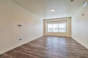 Magna apartment for rent - A room with a wooden floor and a window with blinds.
