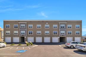 Magna apartment for rent - A parking lot in front of a building with a blue handicap sign painted on the pavement.