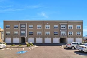 Magna apartment for rent - A parking lot in front of a building with a blue handicap sign painted on the pavement.