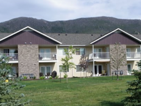 Butte apartment for rent - an image of a large house with a grass yard