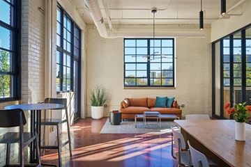 Detroit apartment for rent - A living room with a brown couch and a wooden table.