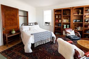 Detroit apartment for rent - A bedroom with a bed, chair, and bookshelf.