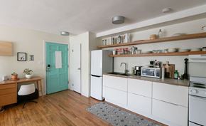 Detroit apartment for rent - A kitchen with white cabinets and a green door.