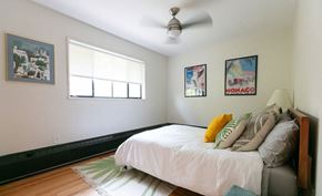 Detroit apartment for rent - A bedroom with a bed, pillows, and pictures on the wall.