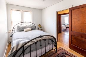 Detroit apartment for rent - A bedroom with a bed and a wooden door.