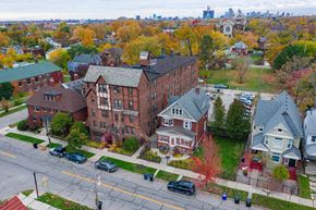 Detroit apartment for rent - A street view of a residential area with cars parked on the side of the road.