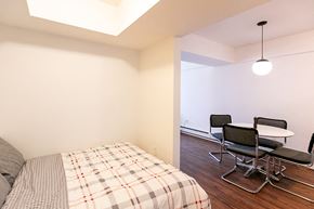 Detroit apartment for rent - A bedroom with a bed and a table with chairs.
