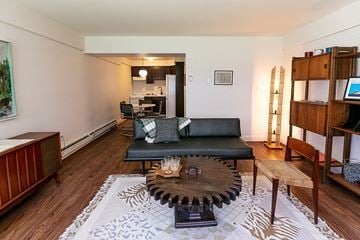 Detroit apartment for rent - A living room with a black couch and a coffee table in the center.