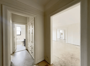 Detroit apartment for rent - A hallway with a door on the left and a room on the right.