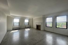 Detroit apartment for rent - A large empty room with a fireplace and windows.