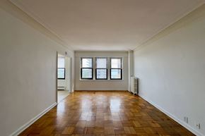 Detroit apartment for rent - A room with wooden flooring and three windows.