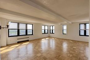 Detroit apartment for rent - A large empty room with wooden flooring and windows.