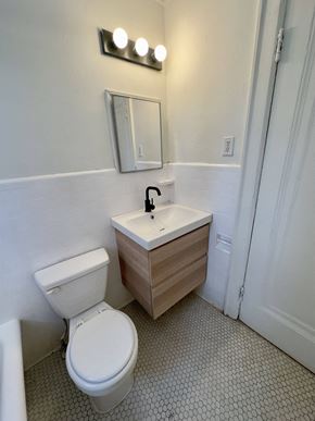 Detroit apartment for rent - A white toilet sits next to a sink in a bathroom.
