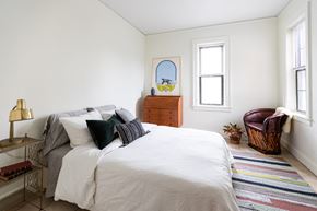 Detroit apartment for rent - A bedroom with a large bed and a chair.