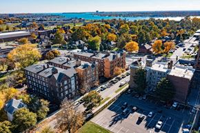 Detroit apartment for rent - A view of a city with a parking lot in the foreground and a large building in the middle.