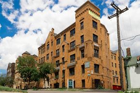 Detroit apartment for rent - A large red brick building with a green sign on the front.