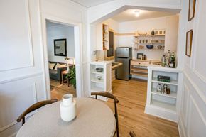 Detroit apartment for rent - A kitchen with a refrigerator, sink, and a dining table with a vase on it.