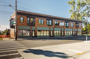 Detroit apartment for rent - A large brick building with a green awning sits on a street corner.