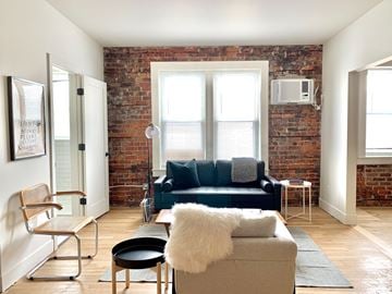 Detroit apartment for rent - A living room with a blue couch and a white fur throw.