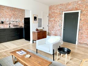 Detroit apartment for rent - A kitchen with a black fridge and a white chair.
