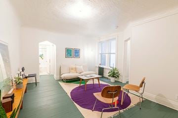 Detroit apartment for rent - A living room with a purple rug and a brown chair.