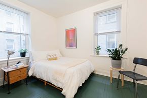 Detroit apartment for rent - A bedroom with a bed, chair, and window.