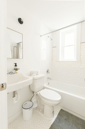 Detroit apartment for rent - A white bathroom with a toilet, sink, and tub.