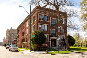 Detroit apartment for rent - A large red brick building with a tree in front of it.