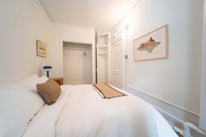 Detroit apartment for rent - A bedroom with a white bed and a painting on the wall.