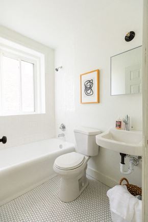 Detroit apartment for rent - A white bathroom with a toilet, sink and tub.