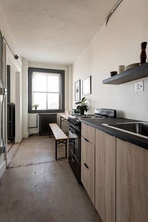 Detroit apartment for rent - A kitchen with a black counter top and wooden cabinets.