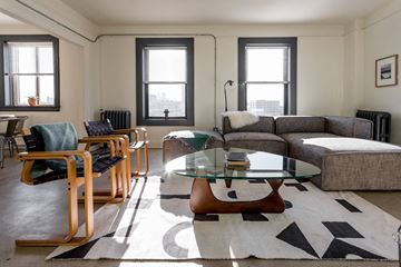 Detroit apartment for rent - A living room with a glass coffee table and a grey couch.