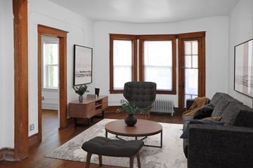Detroit apartment for rent - A living room with a black chair and a brown table.