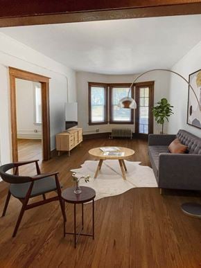 Detroit apartment for rent - A living room with a grey couch, a wooden coffee table, and a chair.