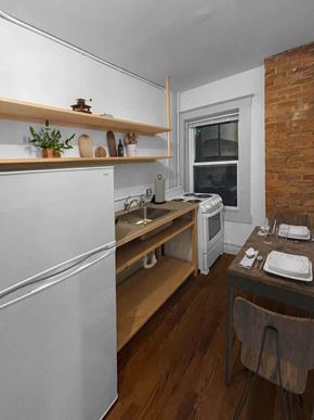 Detroit apartment for rent - A kitchen with a white refrigerator, wooden shelves, and a brown table.