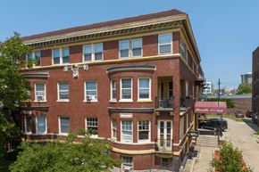 Detroit apartment for rent - A red brick building with a balcony on the second floor.