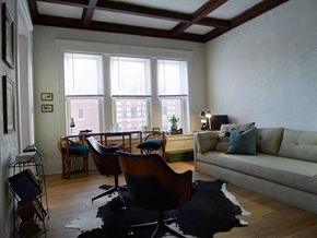Detroit apartment for rent - A living room with a couch, chairs, and a rug.