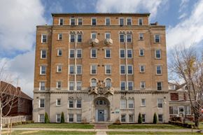 Detroit apartment for rent - A large, two-story building with a balcony on the second floor.